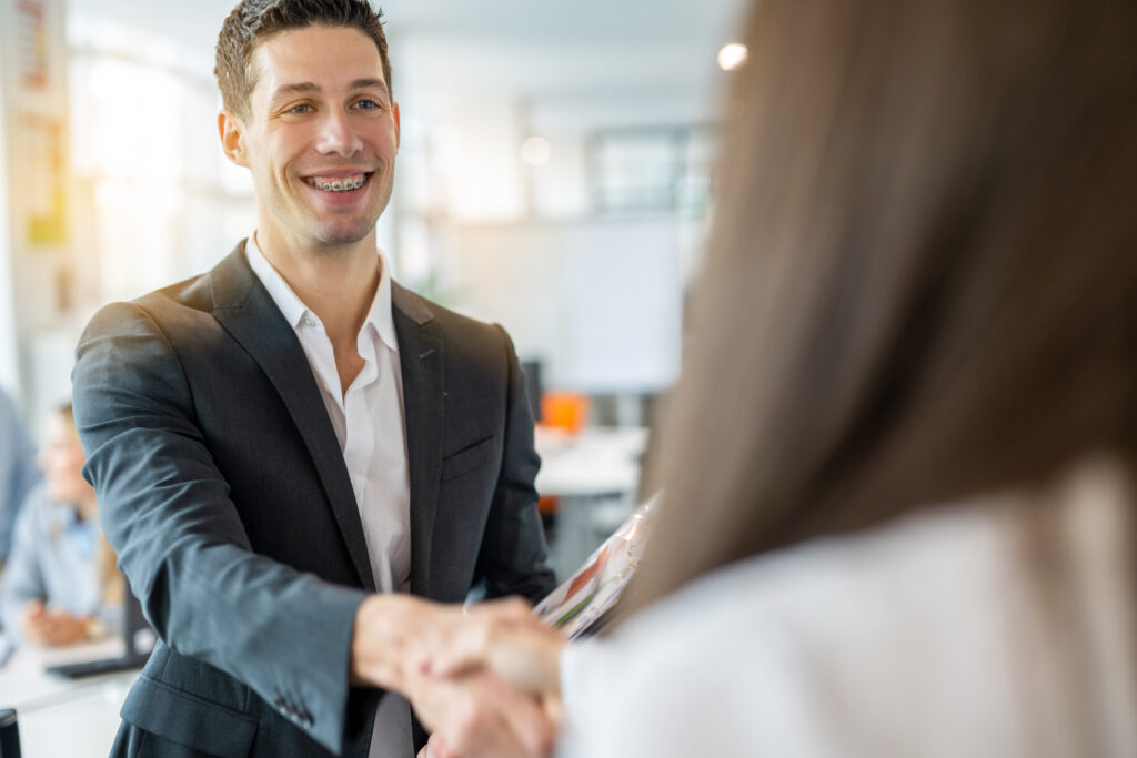 A male direct sales rep shaking hands with a client.